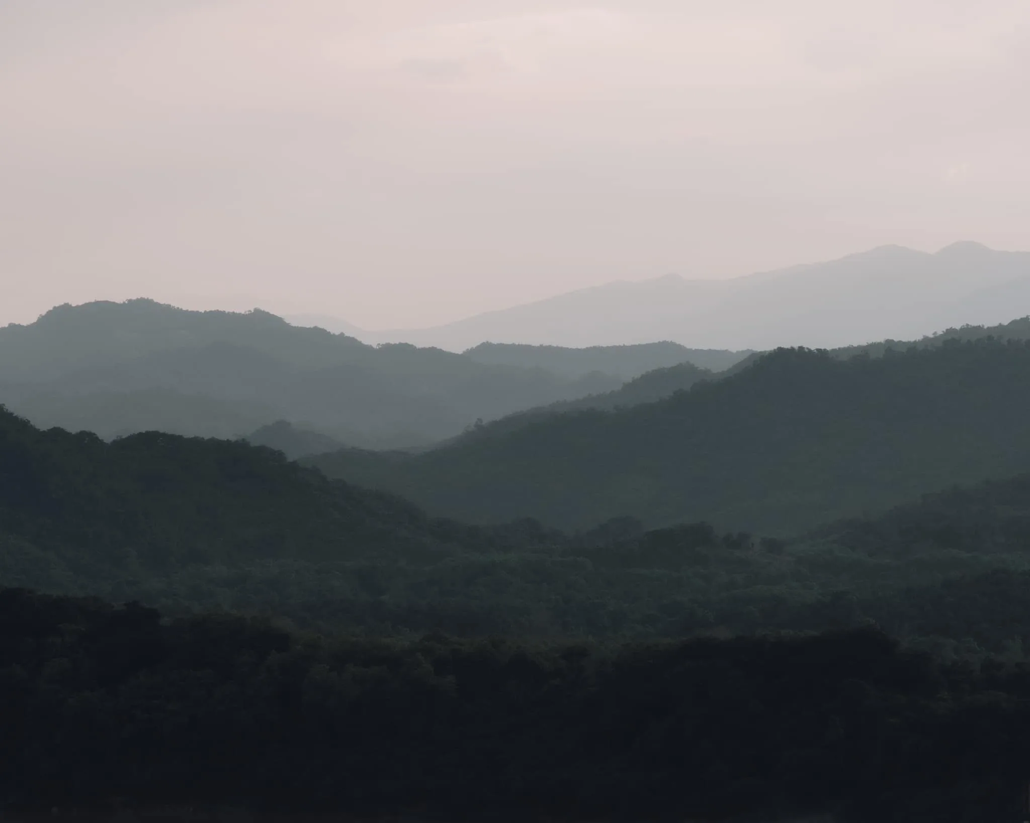 Infinity pool overlooking misty mountains at sunset